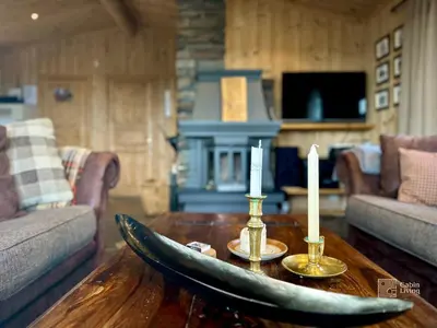 a living room with a table with two candles on it at Cozy spacious cabin with sauna at Natrudstilen in Ringsaker