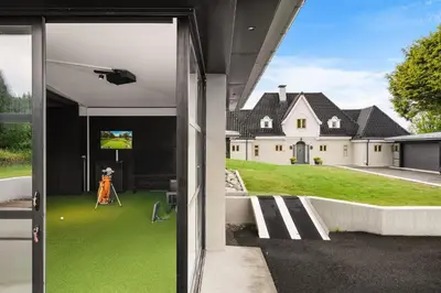 an open door of a house with green grass at Hopsneset Luxury Villa in Bergen