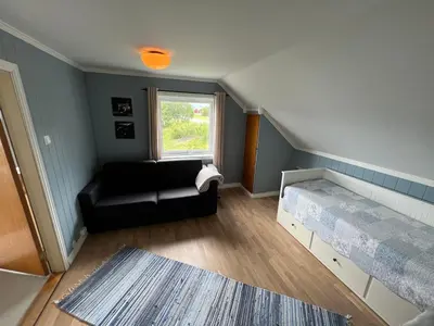 a small room with a couch and a window at Sjønært feriehus, båt tilgjengelig for leie in Ålesund