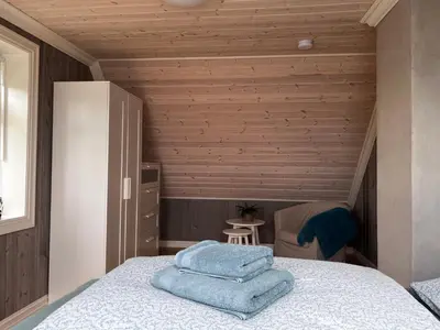 a bedroom with a bed with blue towels on it at Fjord house with a private bay, boats and sauna! in Etnesjøen
