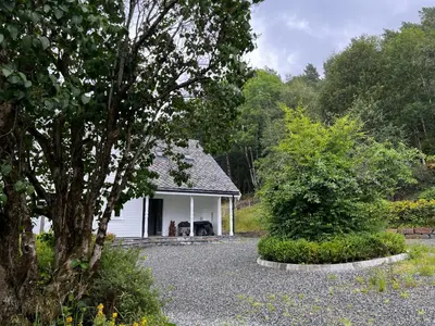 a small white house with two dogs in it at Fjord house with a private bay, boats and sauna! in Etnesjøen