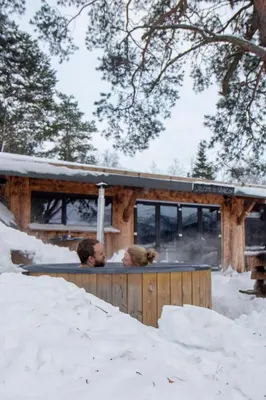two people sitting on a deck in the snow at GapaLux in Levanger