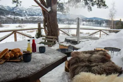 a picnic table in the snow with food on it at GapaLux in Levanger
