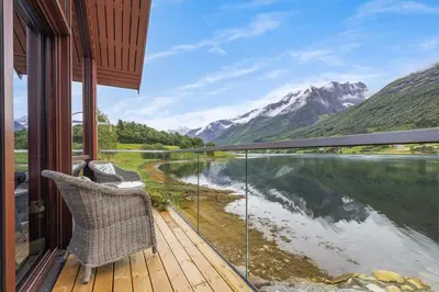a balcony with a view of a river and mountains at Rorbu in Sykkylven