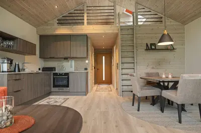 a kitchen and dining room with a table and chairs at Rorbu in Sykkylven