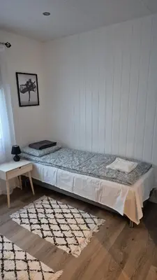 a bedroom with a bed and a table and a rug at Duzy apartament w centrum Ålesund in Ålesund