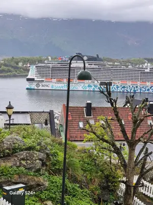 a cruise ship in the water with a cruise ship at Duzy apartament w centrum Ålesund in Ålesund