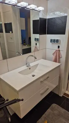 a bathroom with a sink and a large mirror at Duzy apartament w centrum Ålesund in Ålesund