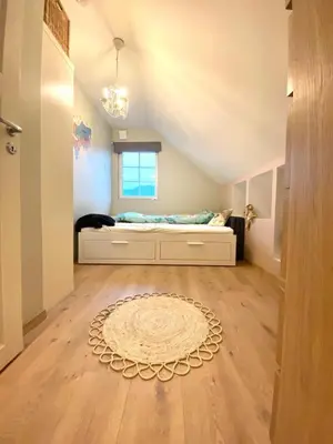 a bedroom with a bed and a cat sitting on a floor at Hus i Stryn in Stryn
