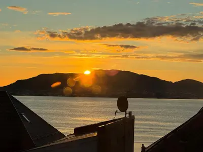a sunset over a body of water with a mountain at Ålesund sentrum apartment in Ålesund