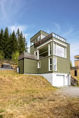 a green house on top of a hill at Moderne og familievennlig bolig, nær populær strand ved Mjøsa in Gjøvik