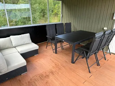 a room with a table and chairs and a couch at Moderne og familievennlig bolig, nær populær strand ved Mjøsa in Gjøvik