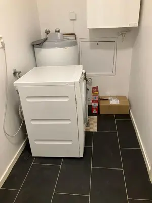 a small white refrigerator in a kitchen with a tiled floor at Moderne og familievennlig bolig, nær populær strand ved Mjøsa in Gjøvik