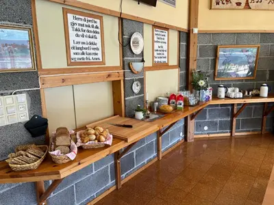 a bakery with wooden tables and baskets of bread at Alværa Misionssenter Sommerhotel in Lavik