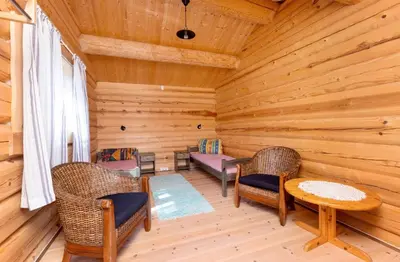 a log cabin with chairs and a table and a bench at Skogcamping in Bjørnstad