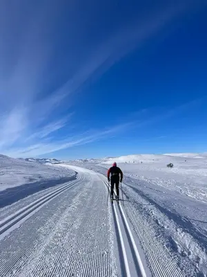 a man is cross country skiing down a snow covered road at Steinstølen by Norgesbooking - cabin with a lovery view in Hol