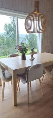 a dining room table with chairs and a large chandelier at Steinstølen by Norgesbooking - cabin with a lovery view in Hol