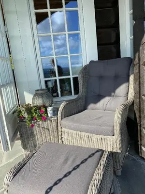 a wicker chair and a couch on a porch at Cozy family cabin with stunning location on Golsfjellet in Golsfjellet