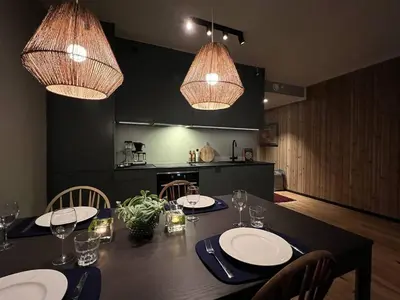 a dining room table with chairs and two chandeliers at Nydelig leilighet på Geilo i Highland fjellandsby in Geilo