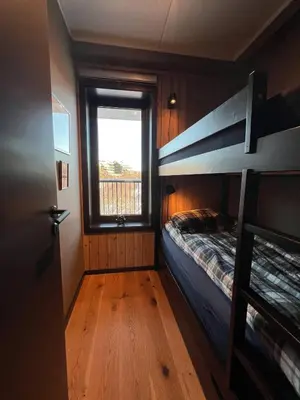 a bedroom with a bunk bed and a window at Nydelig leilighet på Geilo i Highland fjellandsby in Geilo