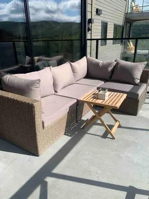 a couch and a coffee table on a patio at Nydelig leilighet på Geilo i Highland fjellandsby in Geilo