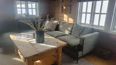 a living room with a couch and a coffee table at Hytte i Myrkdalen in Helgatun