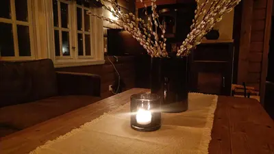 a candle sitting on top of a table with a vase at Hytte i Myrkdalen in Helgatun