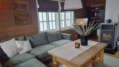 a living room with a couch and a coffee table at Hytte i Myrkdalen in Helgatun
