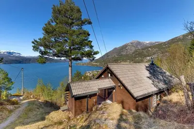 a small wooden house with a view of a lake at Cozy cabin, minimum 5 nights in Oppheim
