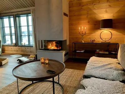 a living room with a coffee table and a fireplace at New, cozy, and comfortable cabin in Geilo in Flatåker