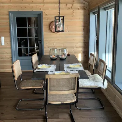 a dining room with a black table and chairs at New, cozy, and comfortable cabin in Geilo in Flatåker