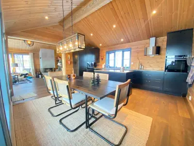 a dining room and kitchen with a table and chairs at New, cozy, and comfortable cabin in Geilo in Flatåker