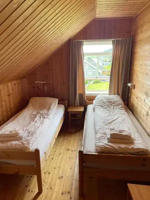 two beds in a room with a window at Vågen Fjordbuer - Snekkerbua in Ravlo