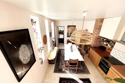 a living room with a dining table and a kitchen at Spacious historical art oasis in the city center in Bergen