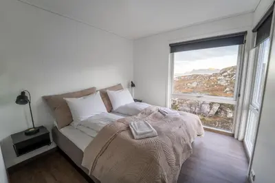 a bedroom with a bed and a large window at Runde Panorama - Highlight View in Runde