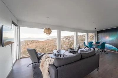 a living room with a couch and a table with chairs at Runde Panorama - Highlight View in Runde