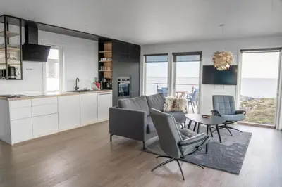 a kitchen and living room with a table and chairs at Runde Panorama - Highlight View in Runde