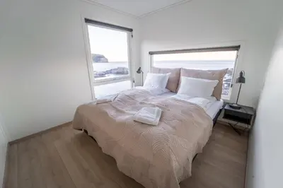 a white bedroom with a large bed and a window at Runde Panorama - Eden in Runde