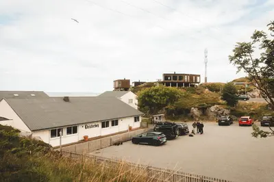 a building with cars parked in a parking lot at Runde Panorama - Eden in Runde