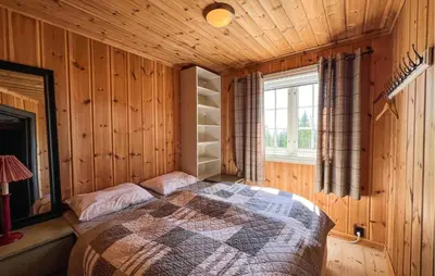 a bedroom with a bed in a wooden room at Amazing Home In Sjusjøen With Sauna in Sjusjøen