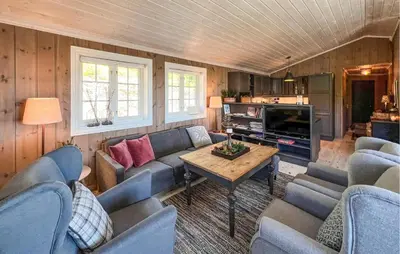 a living room with a couch and a table at Amazing Home In Sjusjøen With Sauna in Sjusjøen