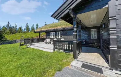 a log cabin with a porch and a grass roof at Amazing Home In Sjusjøen With Sauna in Sjusjøen