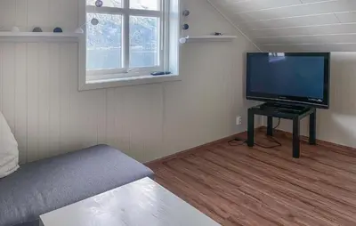 a living room with a flat screen tv on a table at Stunning Home In Vallavik With Wifi in Djønno