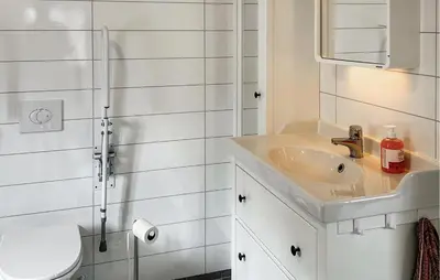a white bathroom with a sink and a shower at Stunning Home In Vallavik With Wifi in Djønno