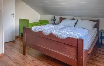 a large bed in a room with a wooden floor at Stunning Home In Vallavik With Wifi in Djønno