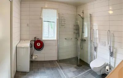 a bathroom with a shower and a toilet and a sink at Stunning Home In Vallavik With Wifi in Djønno