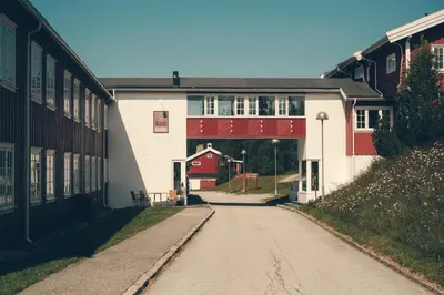a road leading to a building with a red garage at Gålå Høgfjellshotell in Gålå