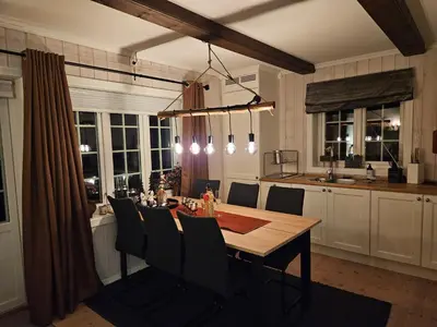 a kitchen with a wooden table and a dining room at Gaustatoppen View Apartment in Gaustablikk
