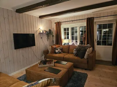 a living room with a couch and a tv at Gaustatoppen View Apartment in Gaustablikk