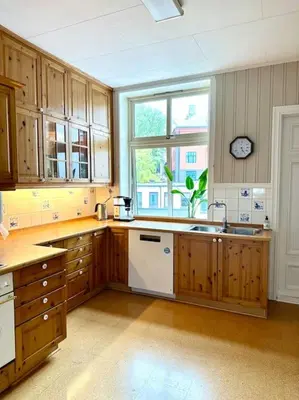a large kitchen with wooden cabinets and a window at Authenic Art Nouveau Apartment in the city-center in Ålesund